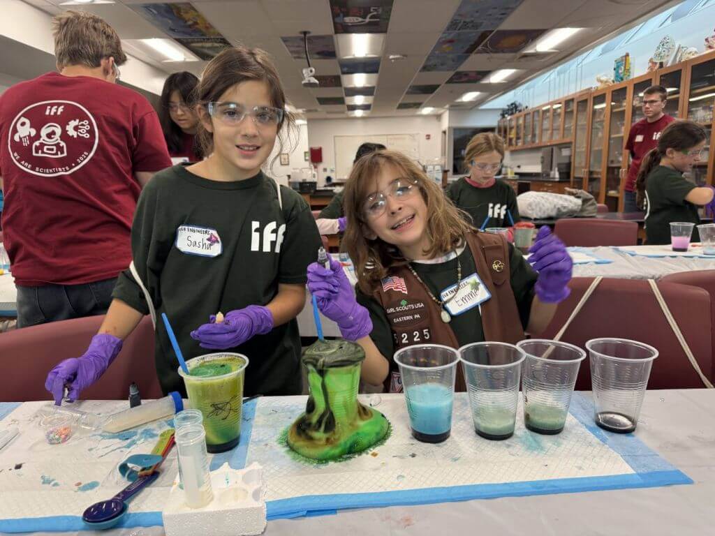 Girl Scouts performing a slime science experiment.