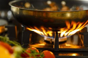 Macro shot of the flame on a gras grill rising underneath a pan