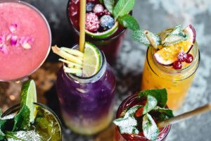 A variety of Dry January-themed brightly colored, non-alcoholic beverages with fruits, garnishes and other toppings. Photo taken from above.